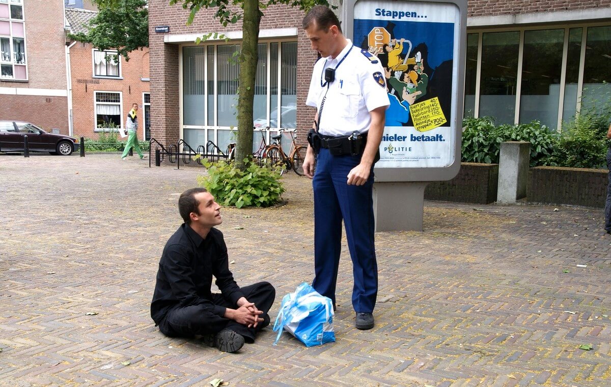 Kraker Rogier in 2008 in gesprek met een politieagent nadat hij drie waterverfbommetjes tegen de gevel van politiebureau Paardenveld heeft gegooid. Foto’s Ton van den Berg