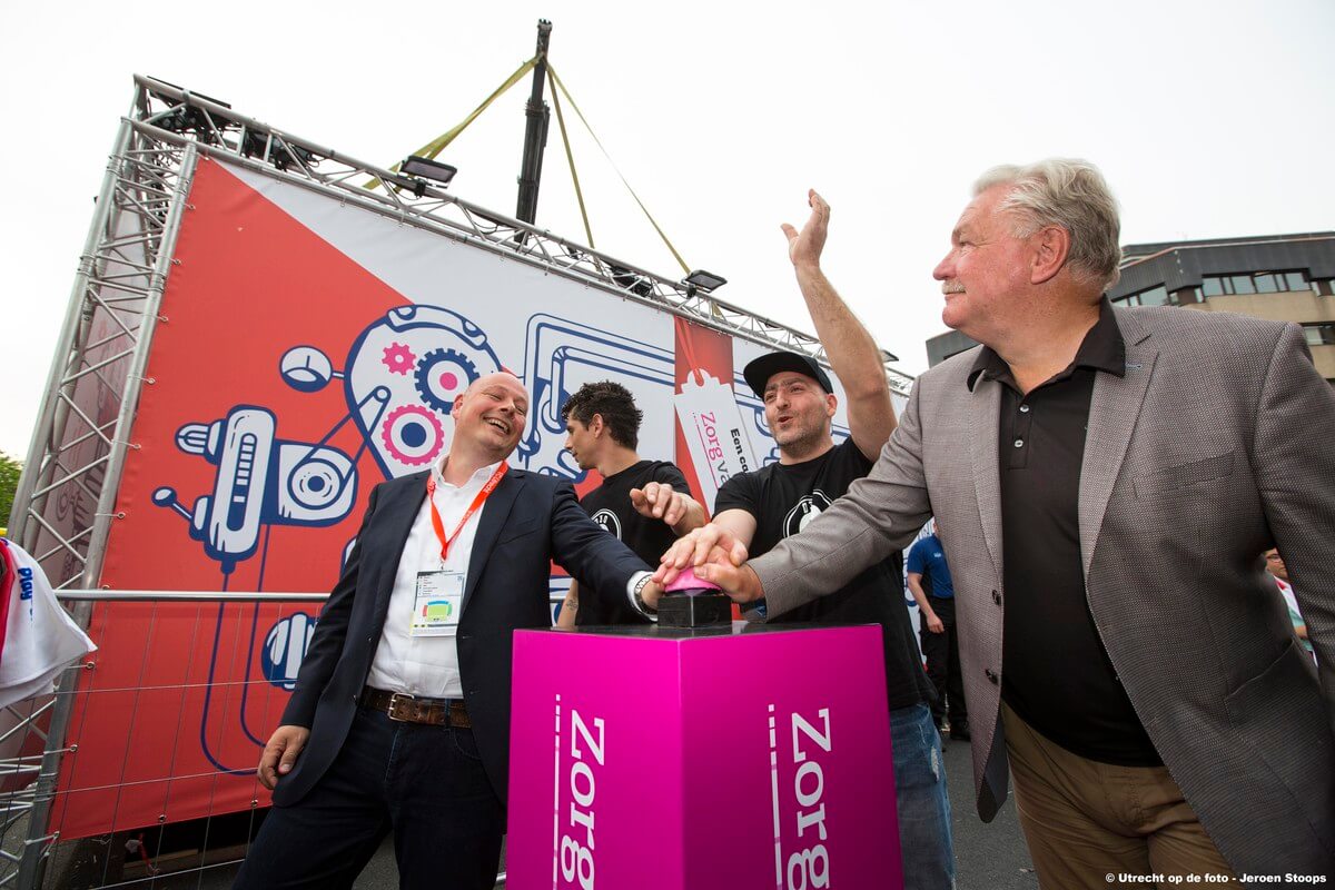 Frans van Seumeren, Zorg van de Zaak directielid Peter van Maris en DJ Barry Paf onthullen het cadeau. Foto: Jeroen Stoops