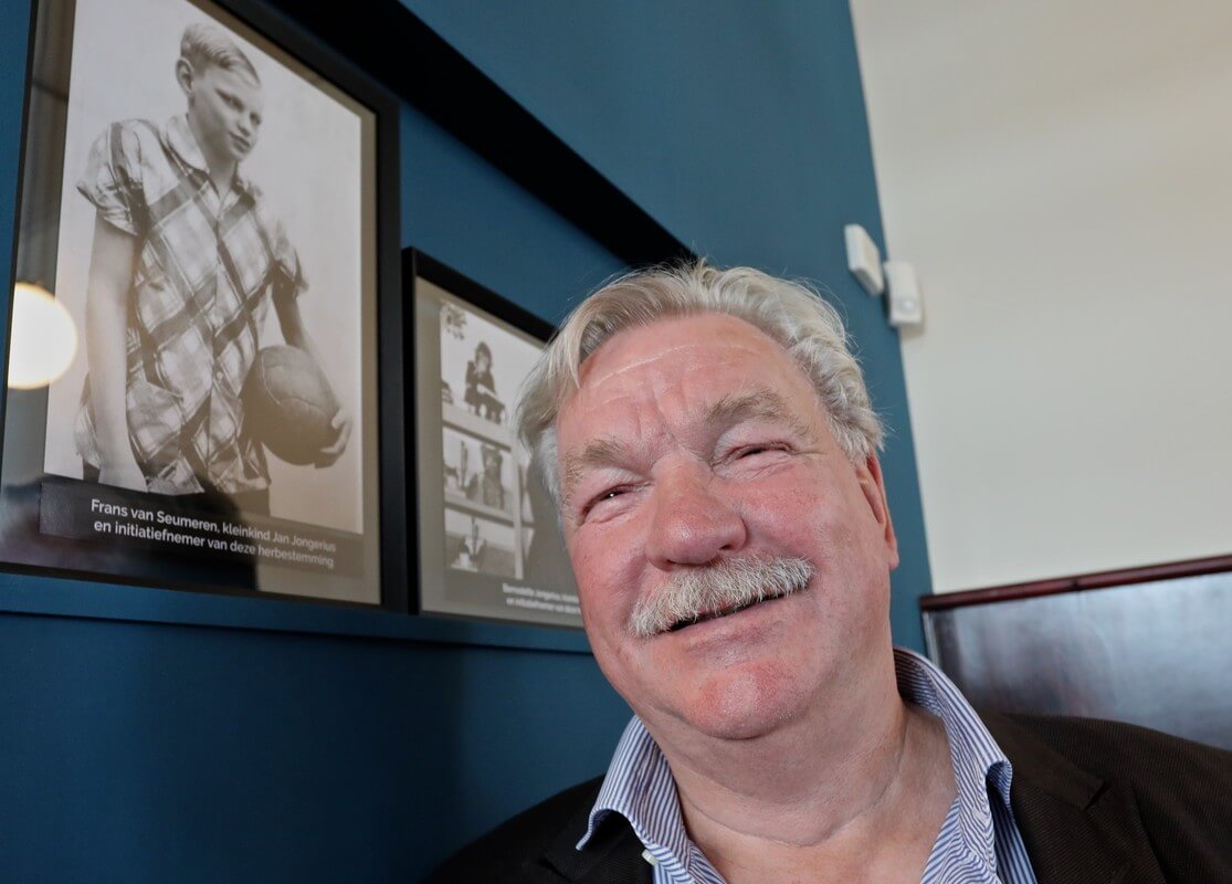 Frans van Seumeren bij een jeugdfoto van hemzelf in het Jongerius Kantoor. Foto: Ton van den Berg