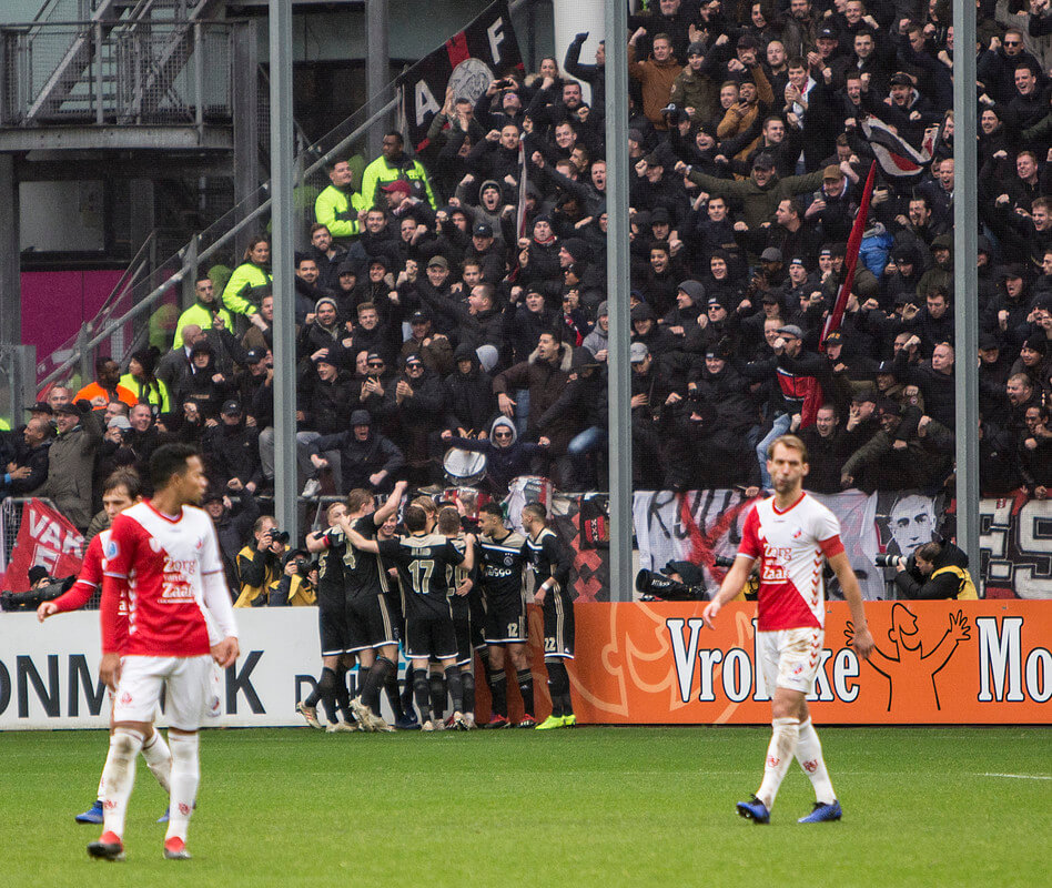 Ajax juicht voor het volle uitvak na het maken van de 0-2 uit een penalty. Veroorzaker Janssen (rechts) baalt.