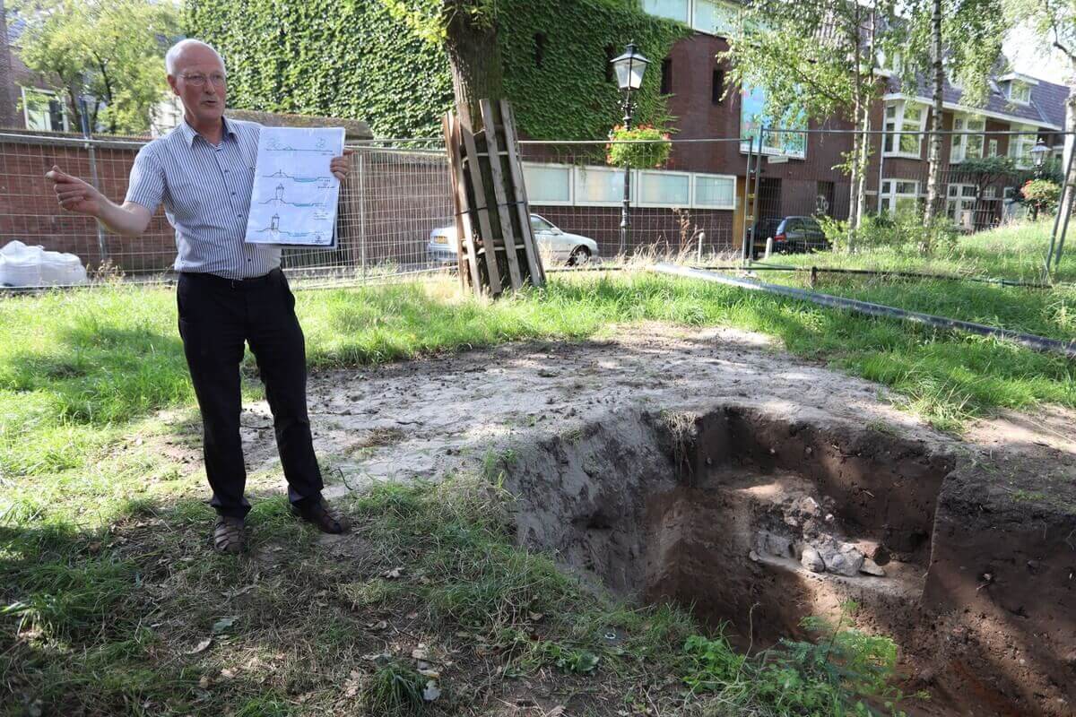 Frans Kipp bij de kuil met daarin de resten van de tufstenen muur. Foto: Ton van den Berg