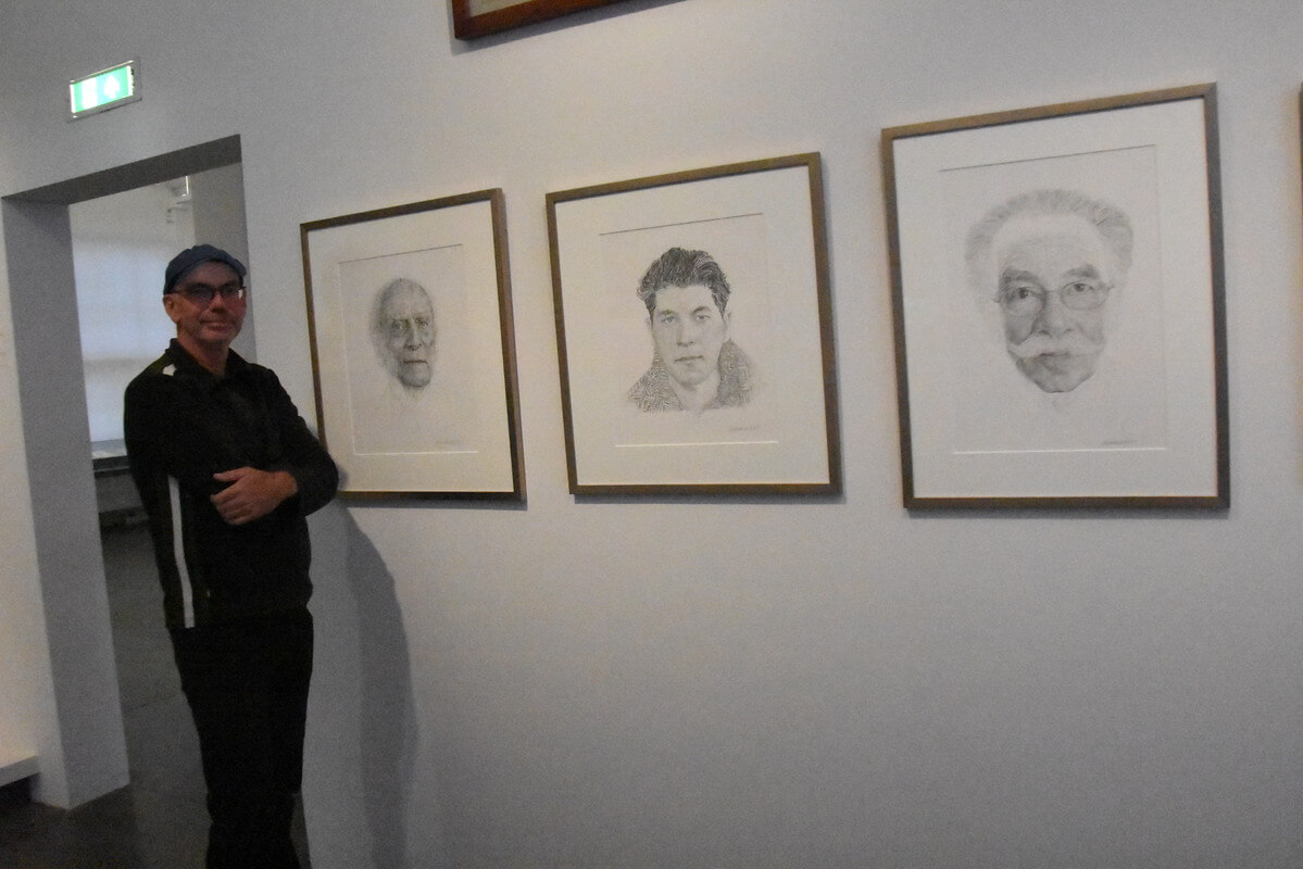 Wennekendonk bij drie van de door hem getekende portretten. Foto: J. Wielaert