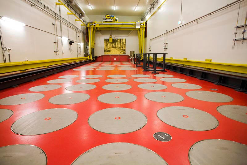 De hal van de Centrale Opslag van Radioactief Afval in Vlissingen waar (onder de grijze deksels) het hoog radioactief afval van Nederlandse nucleaire reactoren voor honderd jaar opgeborgen ligt. Foto: Rob Huibers/Hollandse Hoogte 