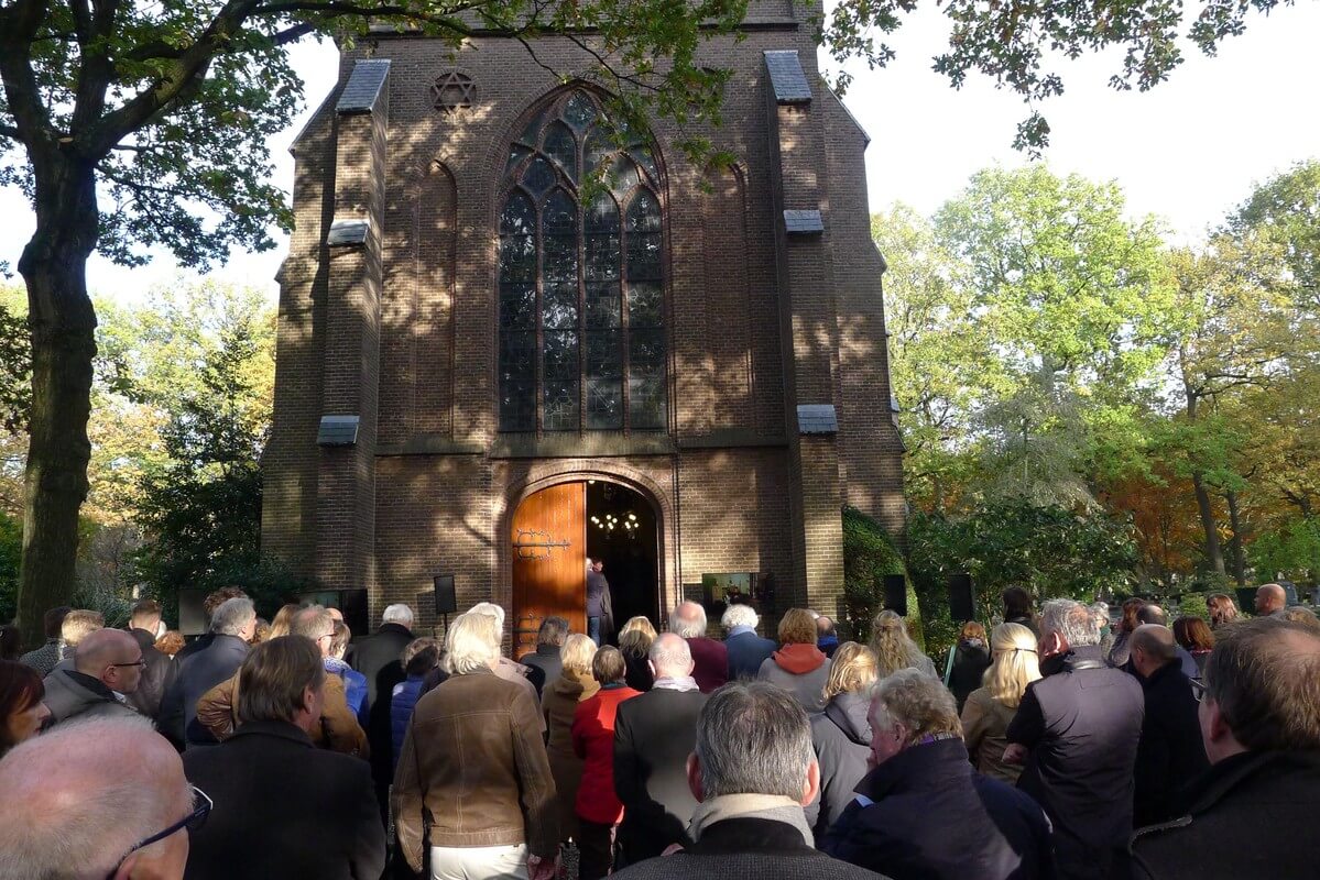 Buiten de kapel is de bijeenkomst ook te volgen. Foto: Ton van den Berg