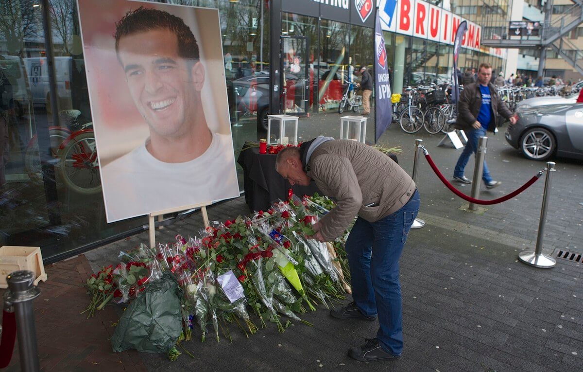 Supporters leggen rode bloemen bij de hoofdingang. Foto: Ton van den Berg