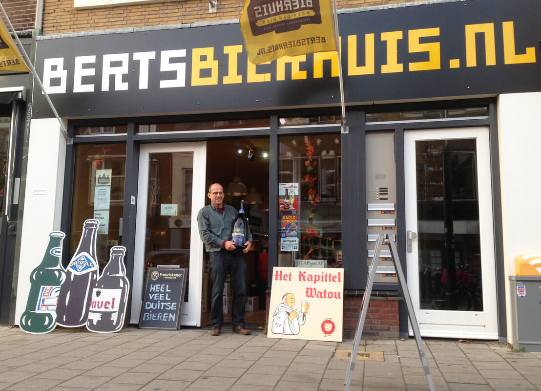Bert de Ruyter voor Berts Bierhuis Biltstraat met een fles bier van 12 liter. Foto: Zita Eijzenbach
