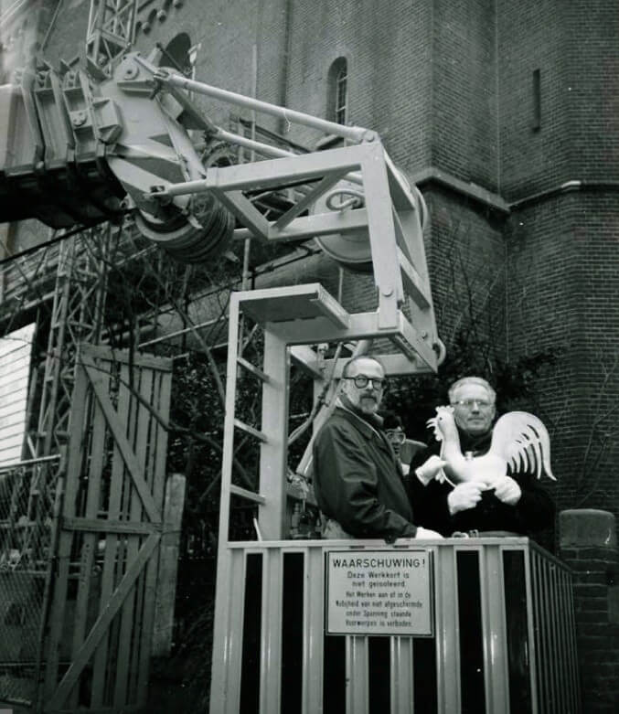 In 1988 krijgt de kerk een vergulde haan, geplaatst door wethouder Van Willigenburg (links) en pastoor Niek van Ditmarsch. Foto: Coen van Kasteel