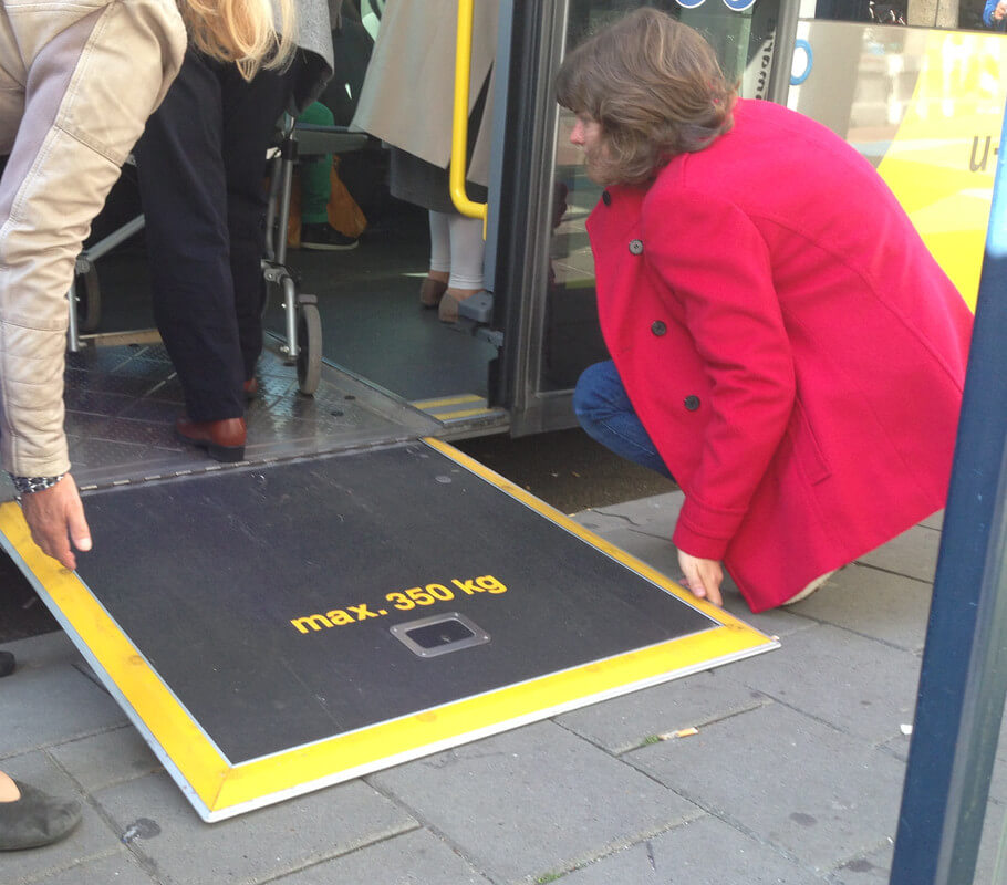 Een medepassagier klapt de klep uit die bedoeld is voor mensen met een rollator of een rolstoel. Foto: Zita Eijzenbach