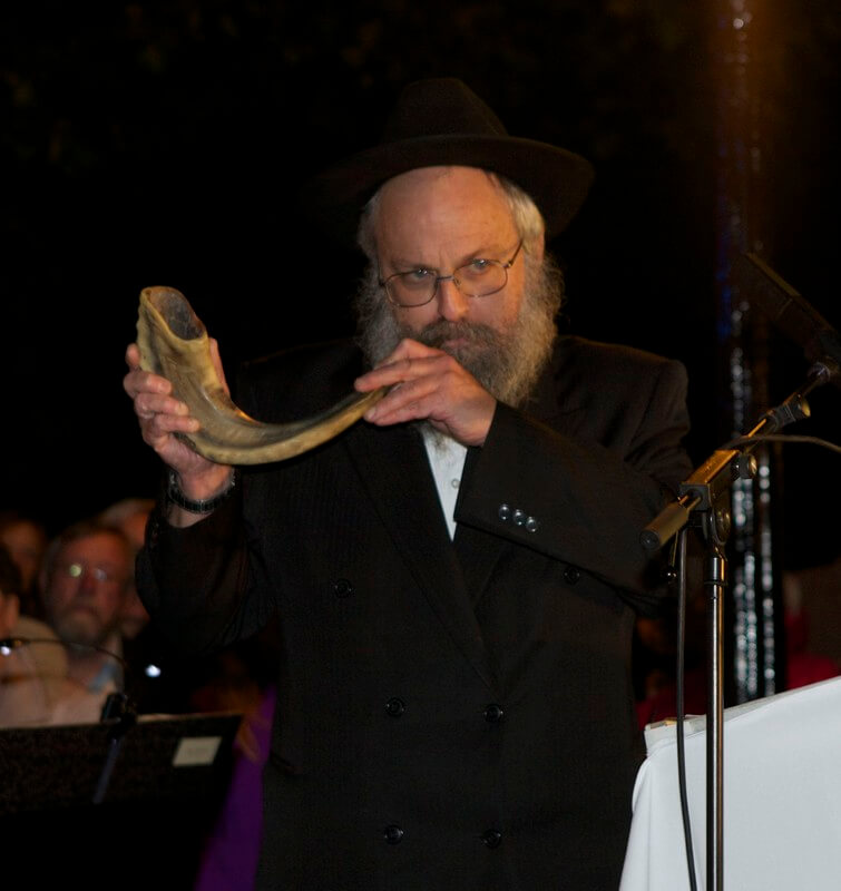 Rabijn Heintz speelt de sjofar. Foto: Ton van den Berg