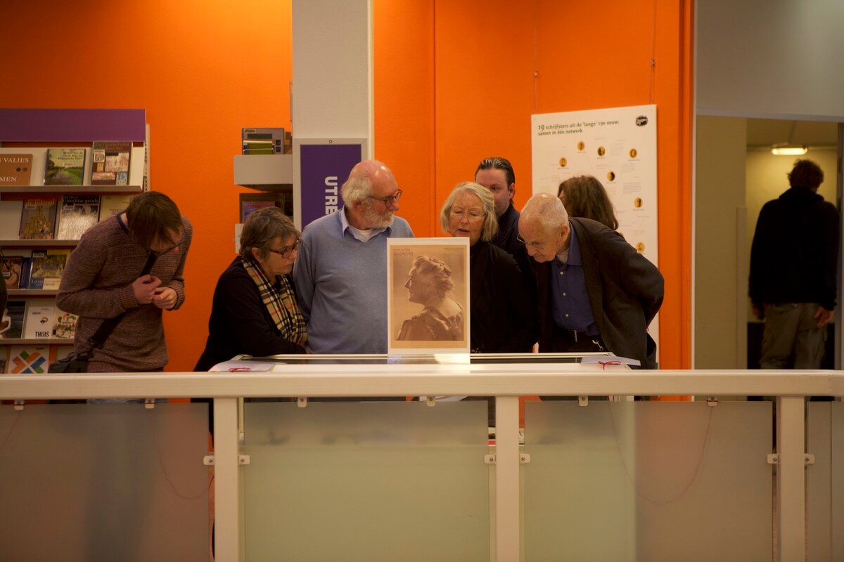 Belangstellenden bekijken de vitrines. Foto: Ton van den Berg