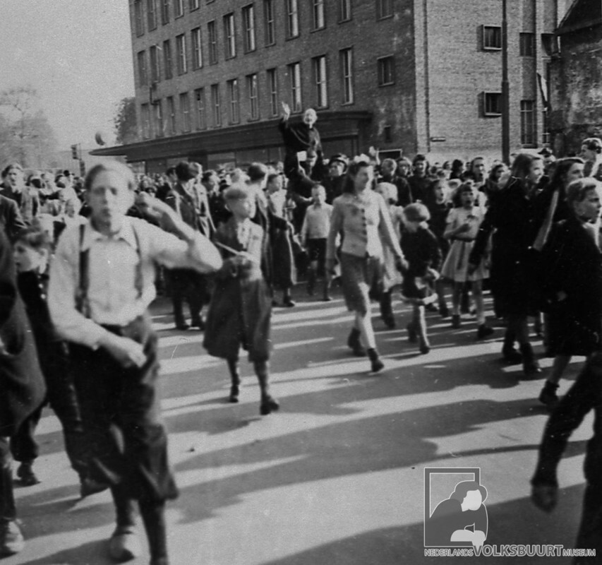 Pastoor Van Nuenen op de schouders in de Jacobsstraat met een menigte Wijk C'ers in mei 1945. Foto: Volksbuurtmuseum