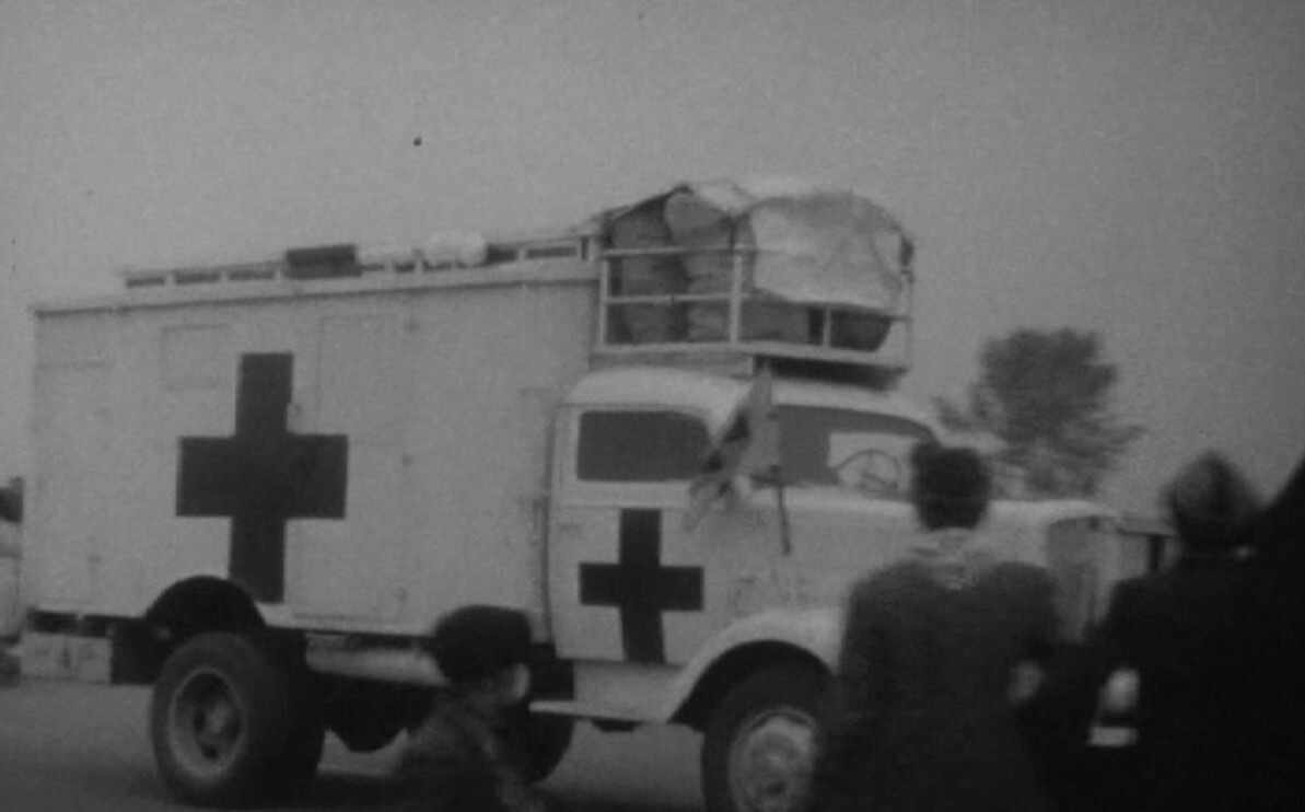 De Rode Kruiswagens rijden de stad in bij de Museumbrug. Foto: Still uit videofilm HUA