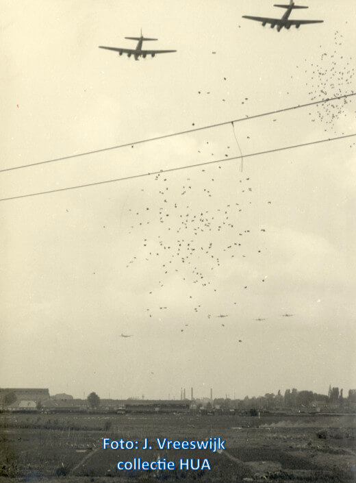Bommenwerpers droppen voedselpakketten boven het stapelterrien van de NS. Foto: J. Vreeswijk (Collectie HUA)