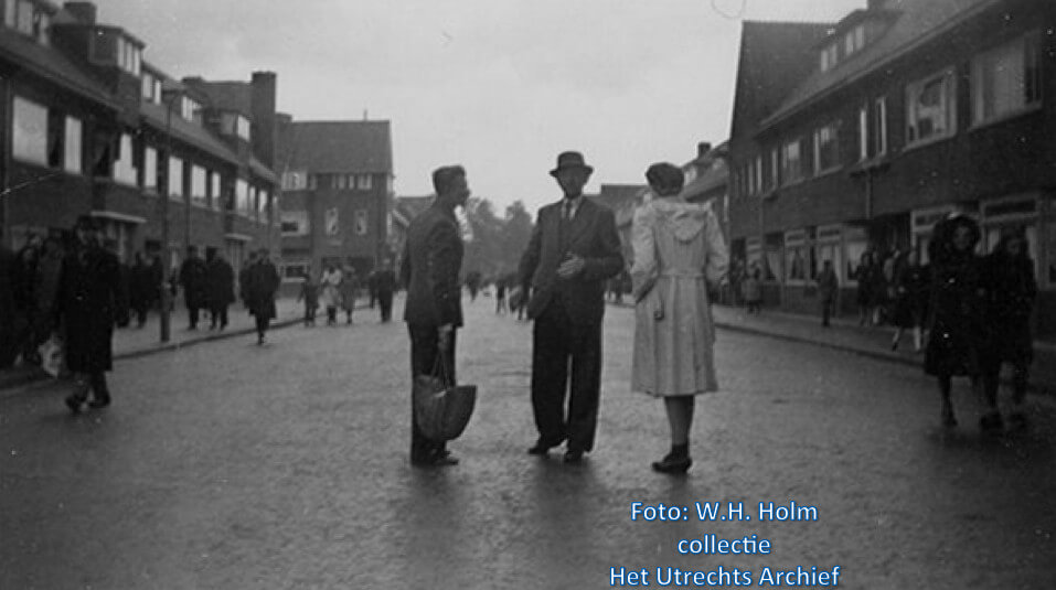 Mensen in de Hasebroekstraat die delen van voedselpakketten hebben weten te bemachtigen die naast het afwerpterrein terechtkwamen, tijdens de voedseldroppings aan de Lage Weide. Foto: W.H. Holm (Collectie HUA)