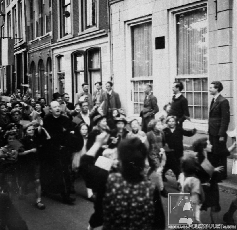 Ook in Wijk C wordt weer feest gevierd en loopt pastoor Van Nuenen voorop. Foto: Volksbuurtmuseum