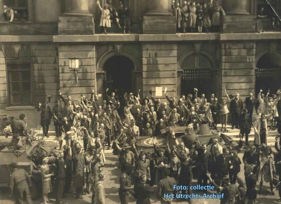 Luitenant Miles (onderop de foto) wordt toegejuicht door de burgemeester en omstanders bij het stadhuis. Foto: Collectie HUA