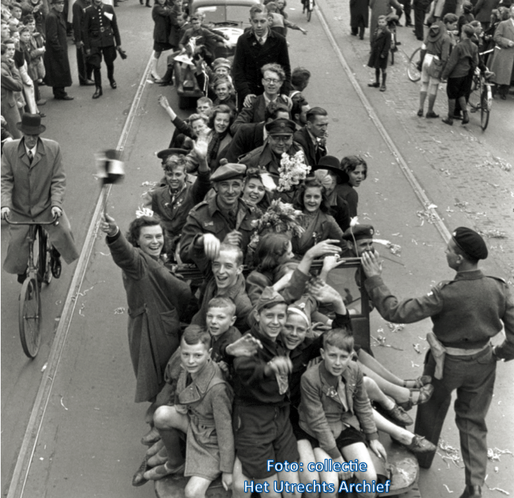 Vooral jongeren kruipen op de voertuigen van de Canadezen. Foto: A.M. Stirton (National Archives of Canada)