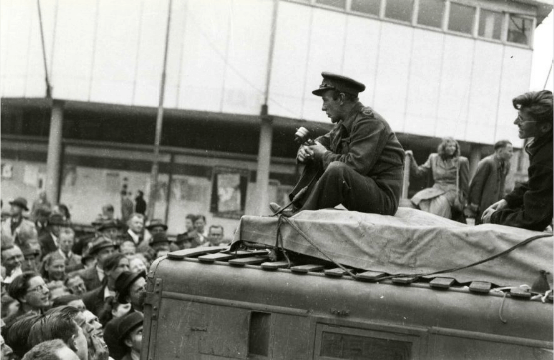 Een journalist doet verslag vanaf een reportagewagen bij de Neude (op de achtergrond het noodgebouw van Galeries Modernes). Foto: H.J. Hoogerhuis (Collectie HUA)