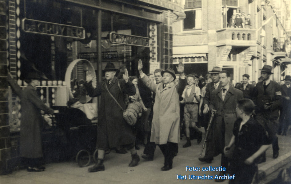 Opbrengen van N.S.B'ers in de Burgemeester Reigerstraat door leden van de Binnenlandse Strijdkrachten. Eén van de B.S.-ers is Kick Strengholt (met bril, achter en tussen de N.S.B.-ers). Foto: F.W. van Malsen (Collectie HUA)