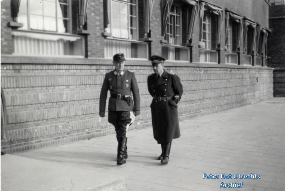 Een Duitse officier van de Wehrmacht en een Utrechtse politieman voor het Hoofdbureau van Politie op het Paardenveld, 1941-1943. Foto: HUA