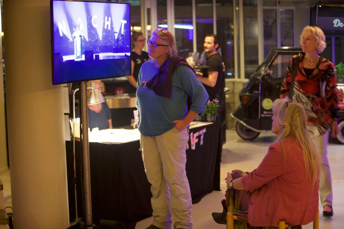 Tot in de gangen van TivoliVredenburg worden de optredens op het podium via beeldschermen gevolgd. Foto: Ton van den Berg