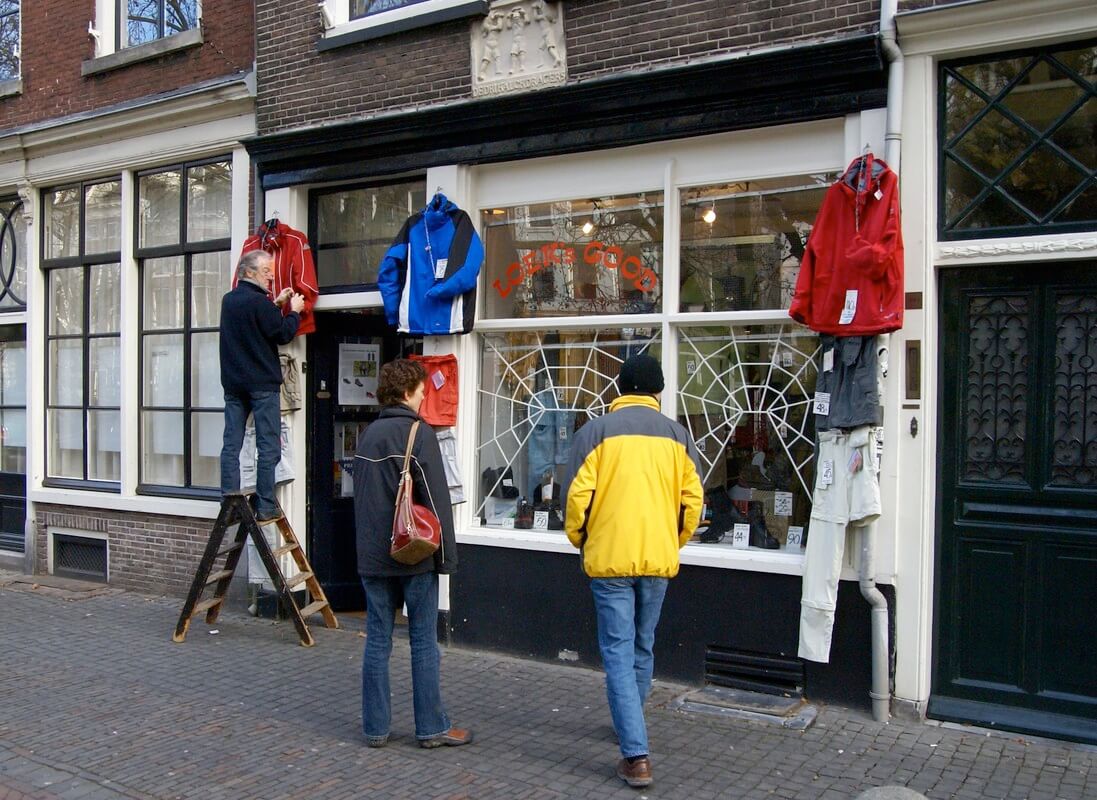 Loek hangt in 2007 kleding aan zijn winkel Loek's Good. Hierover lag hij vaak in de clinch met de gemeente vanwege een uitstalverbod. Foto: Ton van den Berg