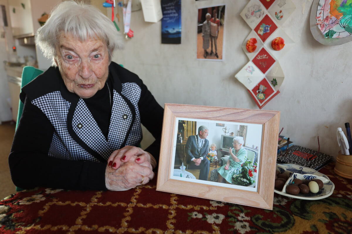 Koosje met een foto waarop burgemeester Van Zanen haar bezoekt bij haar 100'e verjaardag. Foto: Ton van den Berg