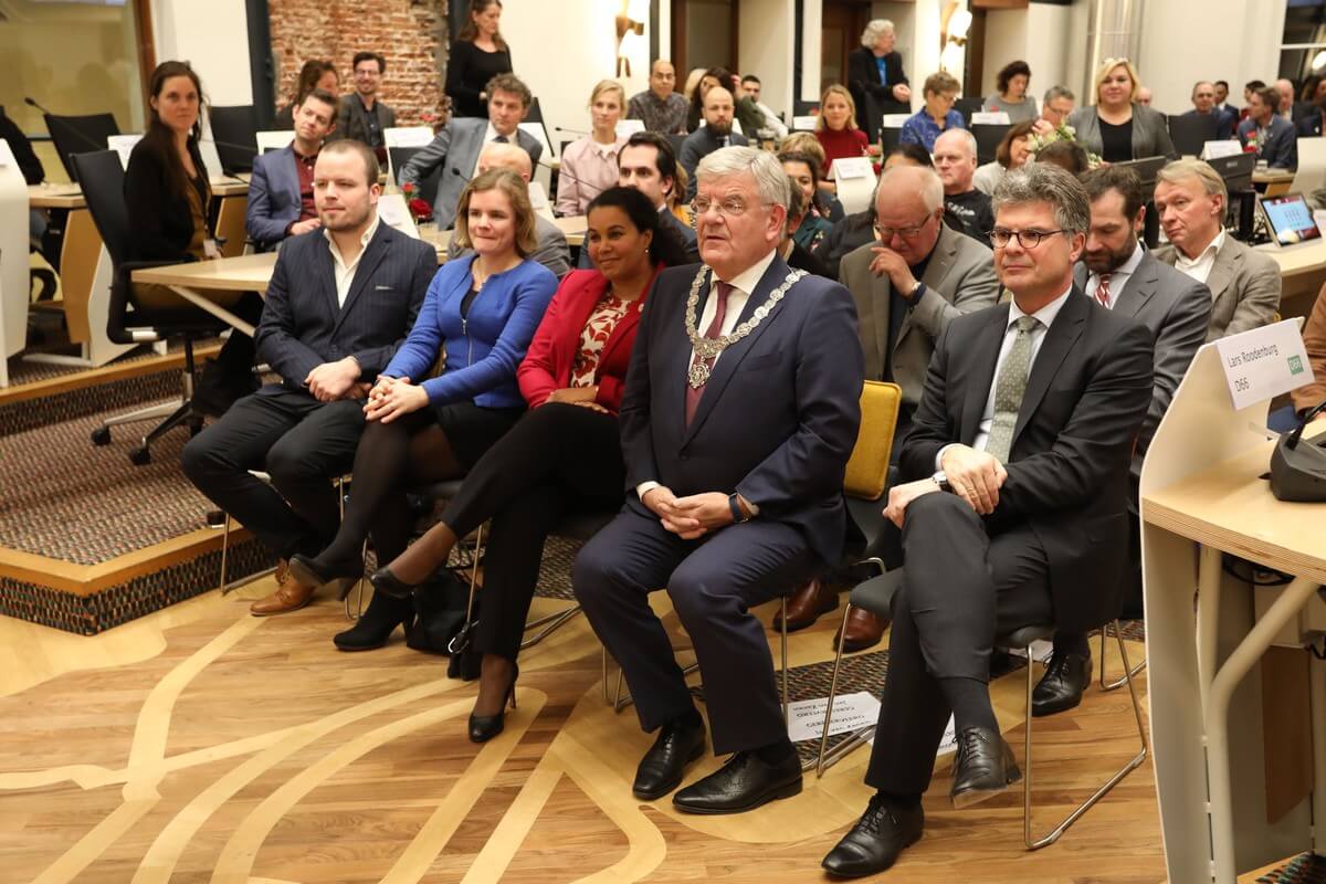 Jan van Zanen met familie en rechts commissaris van de koning Hans Oosters in de raadzaal. Foto: Ton van den Berg