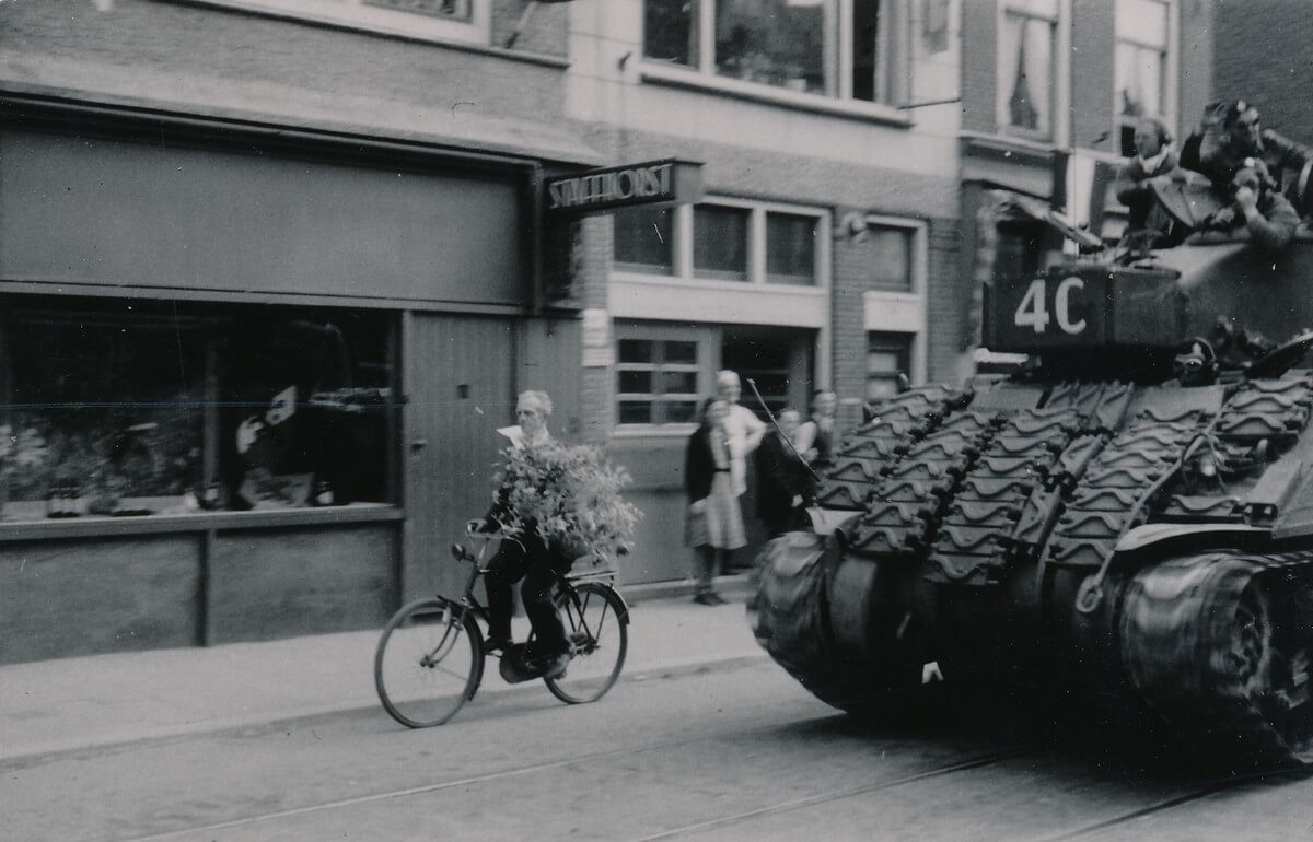 Een fietser waagt zich tussen de legervoertuigen.