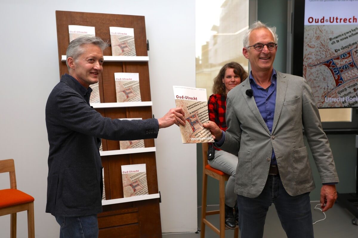 Maxim Februari (links) ontvangt het tijdschrift over Utrecht Boekenstad van Oud-Utrecht-voorzitter Dick de Jong. Foto: Ton van den Berg