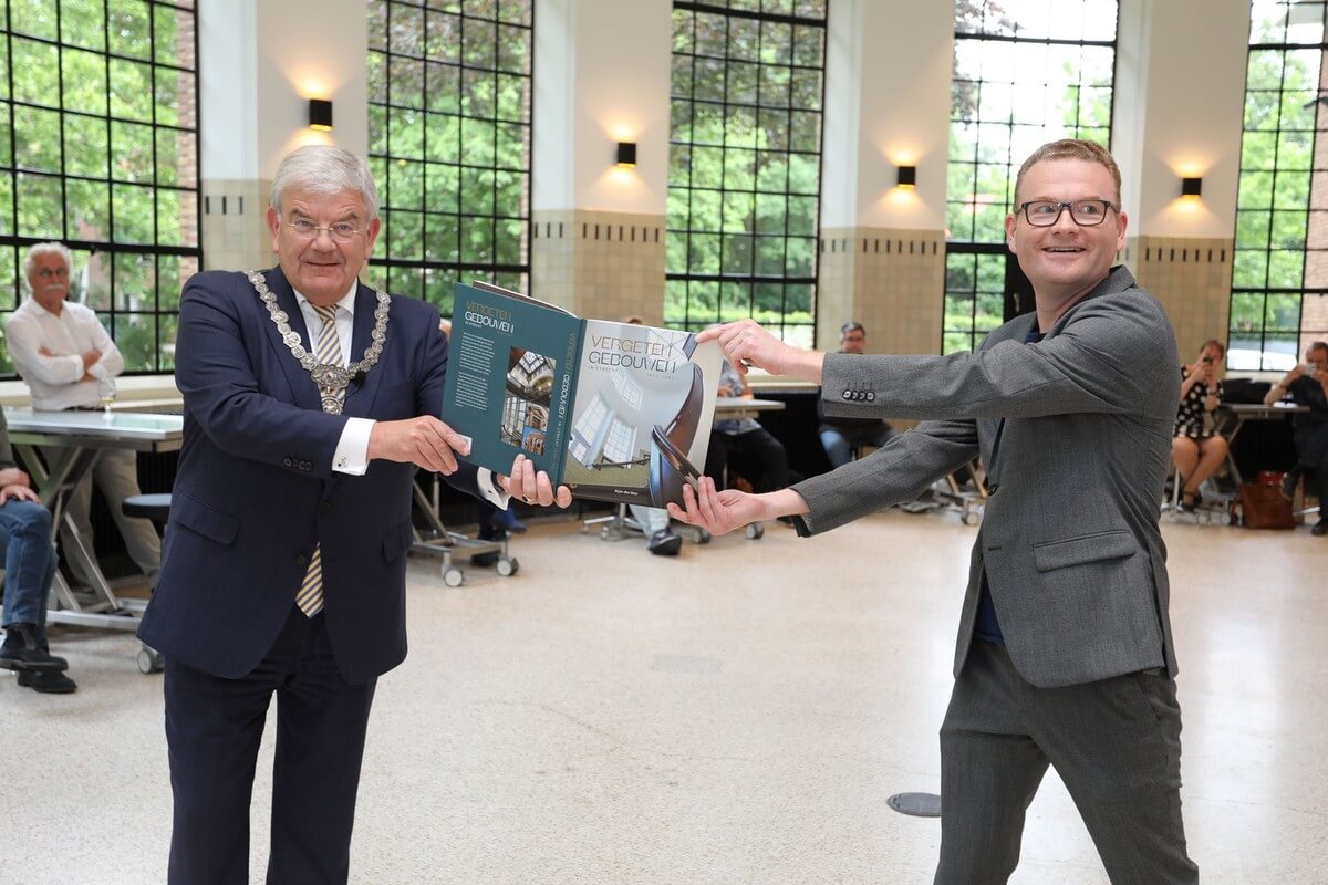 Burgemeester Van Zanen ontvangt het eerste exemplaar van Vergeten Gebouwen uit handen van Arjan den Boer. Foto: Ton van den Berg
